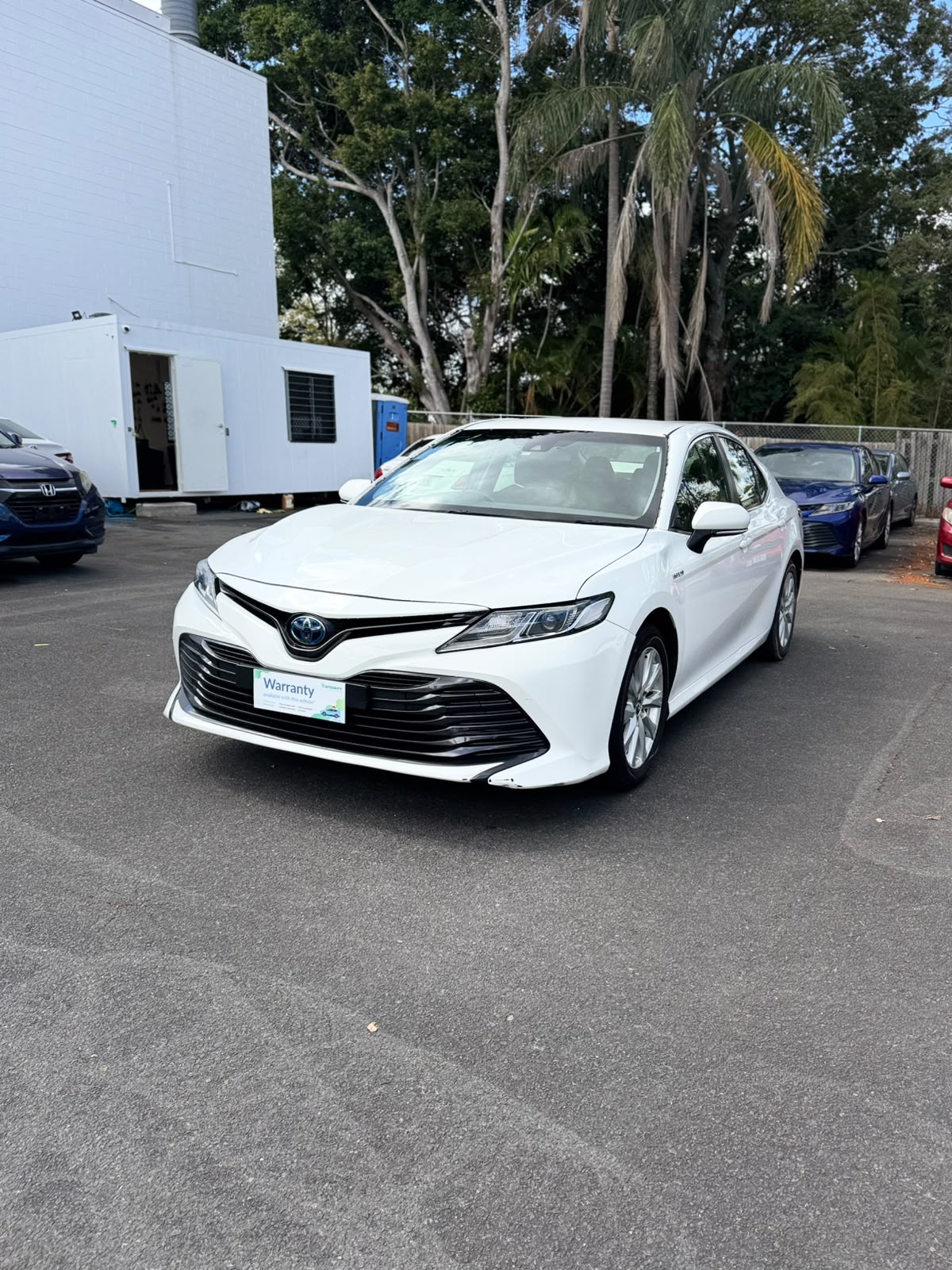 2019 Toyota Camry Ascent Hybrid Sedan in White.