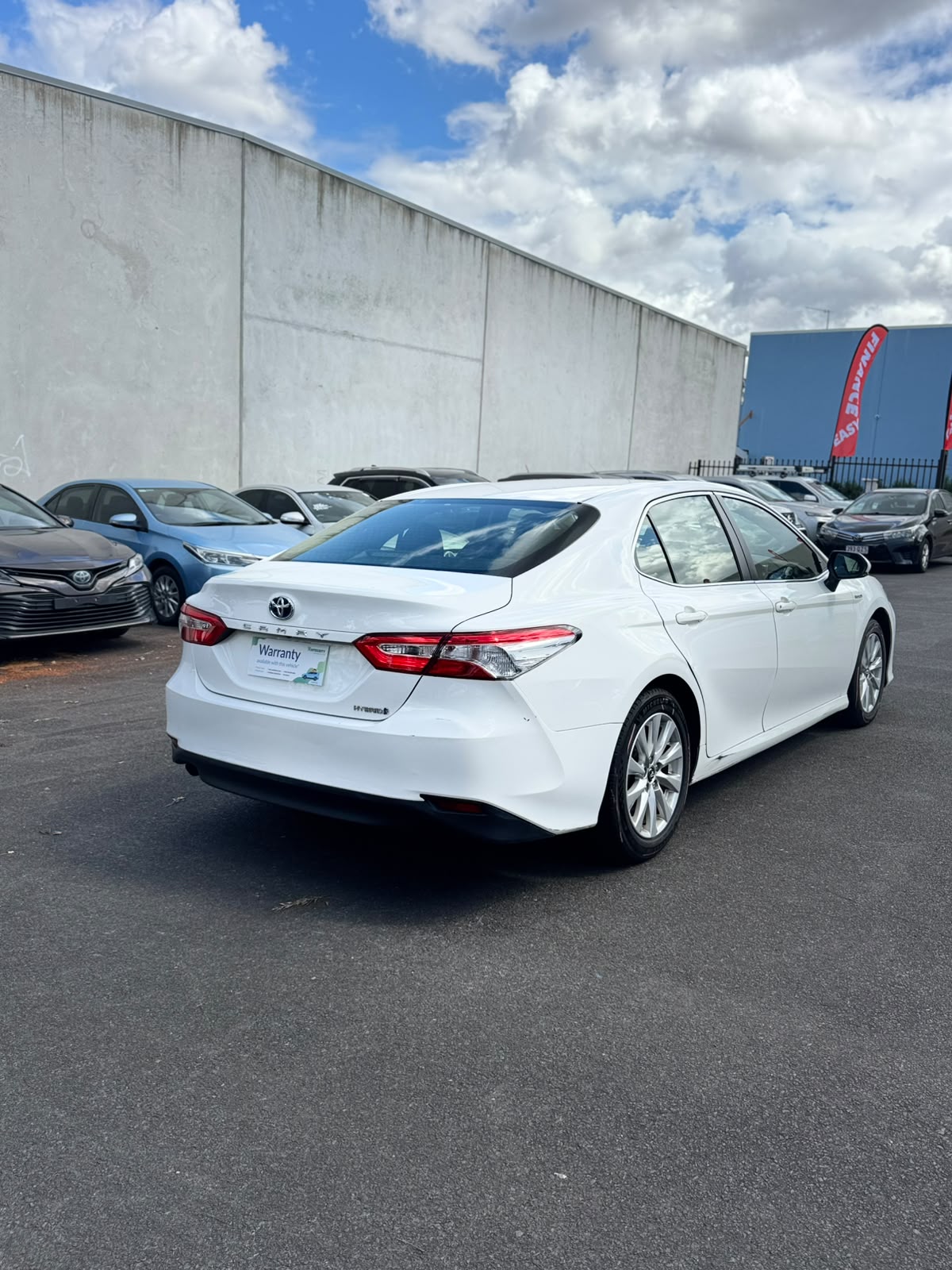 2019 Toyota Camry Ascent Hybrid Sedan in White.