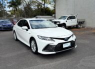 2021 Toyota Camry Hybrid Ascent Sedan in White.